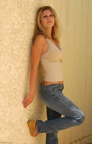 Charming broad flashes breasts and furthermore clean-shaven love button while posing near wall