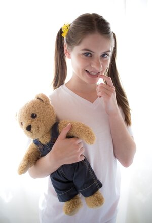 Innocent 18-19 y.o. enters the room with Teddy in hands and puts it aside to strip