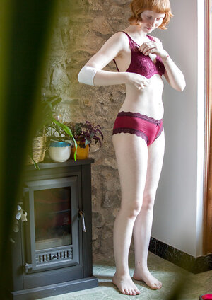 Pale redhead girl covers natural titties with burgundy lingerie on the spy camera