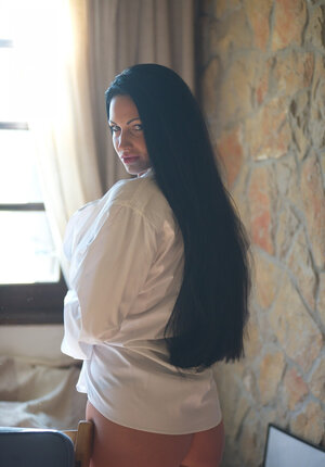 Luscious black-haired bimbo casually peels underwear to pose in bare nudity