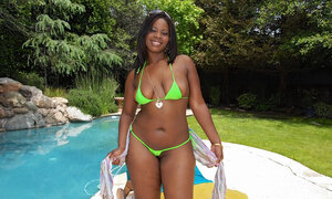 Fleshy ebony playing by the pool while wearing her bikini